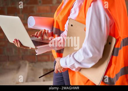 Construction specialists using computer during inspection of building Stock Photo