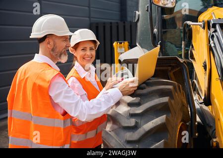 Construction professionals checking data on laptop during building inspection Stock Photo