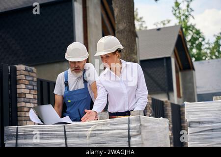 Project contractors analyzing house plans in development area Stock Photo