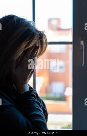 Woman with hands on her face suffering from mental problems and depression. Stock Photo