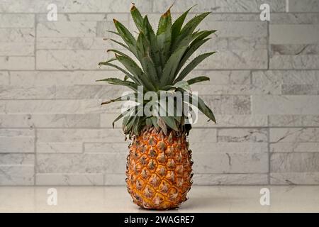 Whole Pineapple Standing Upright On Restaurant Counter, Bokeh Background, pineapple stands. Stock Photo