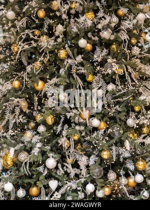 White and golden christmas toys, tinsel, baubles on fir Christmas tree, christmas background Stock Photo
