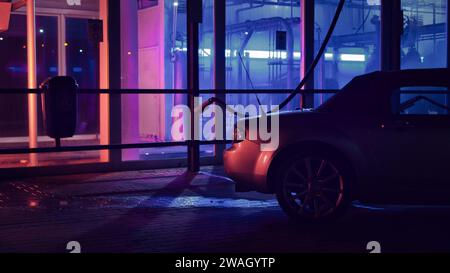 Silver JDM convertible at night in front of a car wash and neon lights Stock Photo