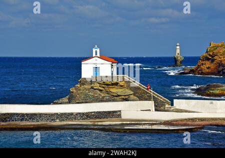 church Panagia Thalassini and Tourlitis lighthouse on the rocky coast, Greece, Cyclades, Andros Stock Photo