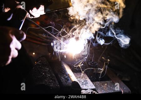 Welding metal with electrodes, sparks and smoke Stock Photo
