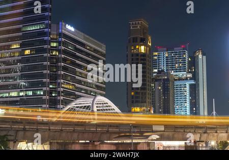 Passing metro train bts on an overpass among skyscrapers at Chong Nonsi pedestrian bridge in Bangkok, Thailand 27 december 2023. Stock Photo