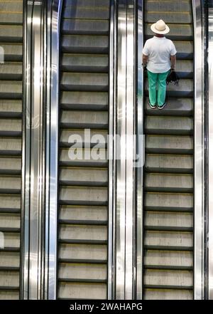 Men travelling up an escalator in Wynyard train station, Sydney, NSW, Australia Stock Photo