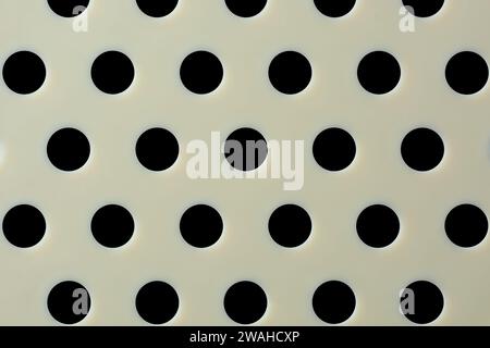 close-up macro view of plastic food strainer, abstract of beige color surface with round holes, mesh of holes or perforated wallpaper background Stock Photo