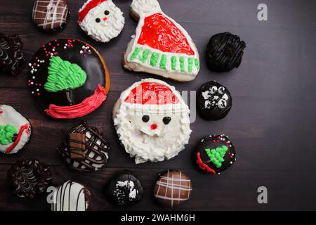 Homemade Glazed Christmas Donuts. Assorted Christmas design donuts include reindeer, Santa Claus, Xmas tree, and chocolate. festival background. Stock Photo