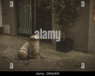 The two stone bollards chained together on a narrow street in Seville, Andalusia, Spain. Stock Photo