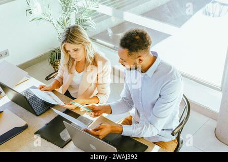 Two coworkers analyzing data while working together in the office. Business concept. Stock Photo