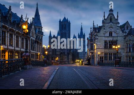 Historical buildings and street lights at dawn in Ghent with Saint Bavo's Cathedral in the background Stock Photo