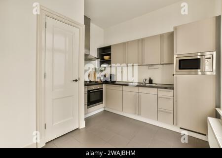 Interior of spacious kitchen with modern appliances and white cabinets at contemporary apartment Stock Photo