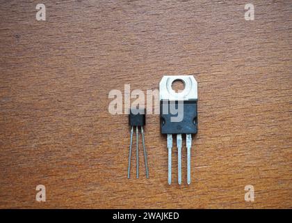 Semiconductor components on wooden background. transistors in two different cases. Stock Photo