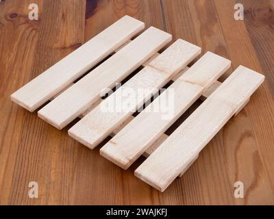 Traditional Classic hard wood hand made hot pan trivet on a kitchen worktop Stock Photo