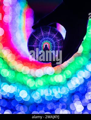 Fun shot of a light tunnel as seen in a glass lensball with rainbow coloured lights Stock Photo