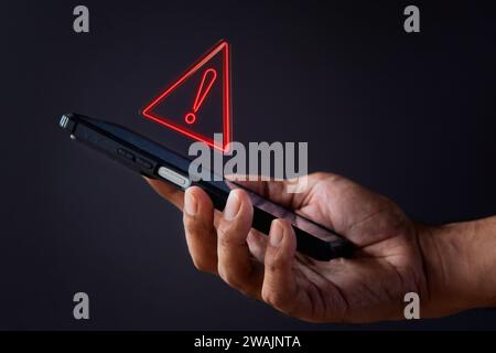 Smartphone with triangle caution warning icon. System error, malware and cyber crime concept. Stock Photo
