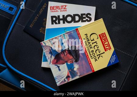 Rhodes Berlitz Travel Guide book and Greek phrase book & dictionary with British passport on suitcase - holiday vacation travel concept Stock Photo