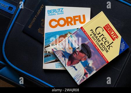 Corfu Berlitz Travel Guide book Greek phrase book & dictionary with British passport on suitcase - holiday vacation travel concept Stock Photo