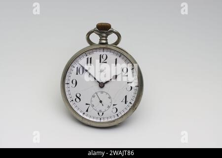 Functional vintage pocket watch with hairline cracks on dial, dirt inside and scratched glass Stock Photo