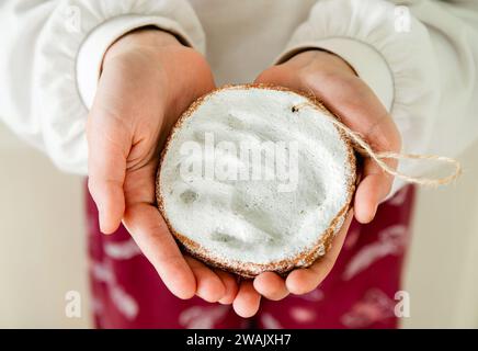 Girl child holding herself handmade baby hand print inside clay for memory in home room. Stock Photo