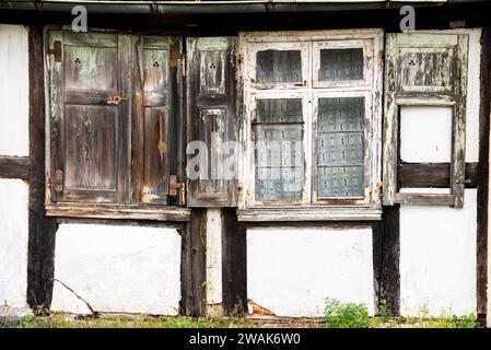 Old broken windows and facade of a country house in the countryside. Stock Photo