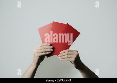 Hand holds angpao or red monetary gift on white background. Chinese New Year concept. Gong Xi Fa Cai. Stock Photo