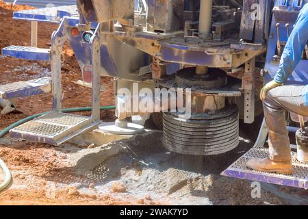 When water is flowing from well from water supply hole is drilled in ground. Stock Photo
