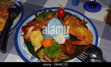 Rice in a cone shape or called Nasi Tumpeng A festive Indonesian rice dish with side dishes Stock Photo