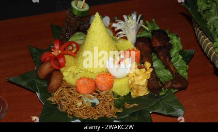 Rice in a cone shape or called Nasi Tumpeng A festive Indonesian rice dish with side dishes Stock Photo