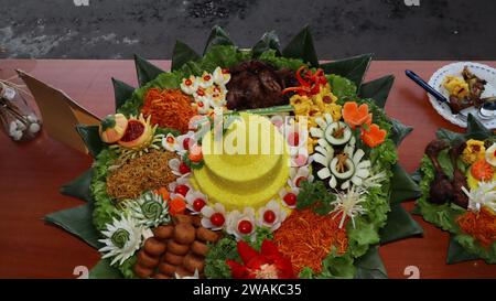 Rice in a cone shape or called Nasi Tumpeng A festive Indonesian rice dish with side dishes Stock Photo