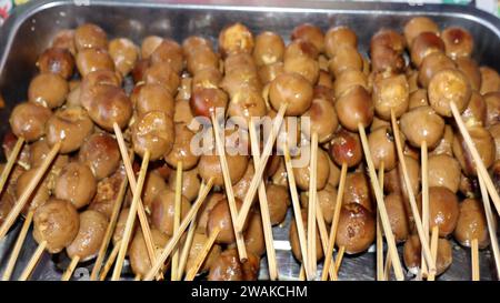 Quail eggs satay. Several hard-boiled quail eggs are put into skewers, marinated in sweet soy sauce with spices and boiled further, also served as a s Stock Photo
