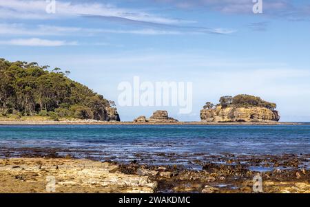 The Tessellated Pavement at Pirates Bay Beach, Tasmania, looking across to Clyde's Island. Summer view with blue sky. Stock Photo