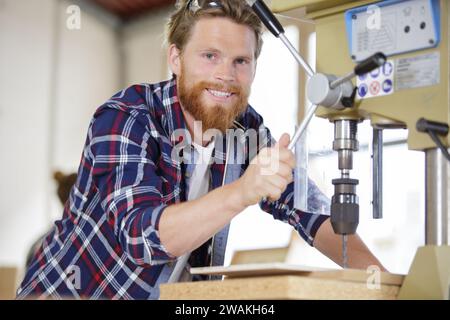 workman using a bench drill Stock Photo