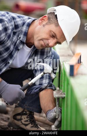 builder putting down a hammer on a building site Stock Photo