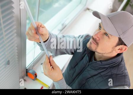 young man installing window blinds Stock Photo