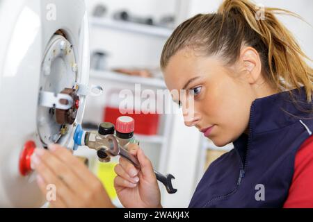 female technician servicing a boiler Stock Photo