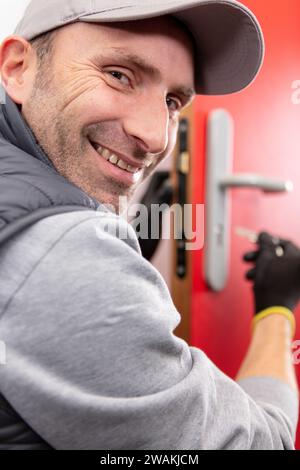 handyman fitting a new door using a screwdriver at home Stock Photo