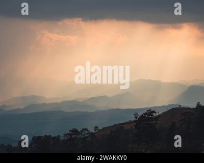 A dramatic sunset sky featuring a large rain cloud in the foreground. Stock Photo