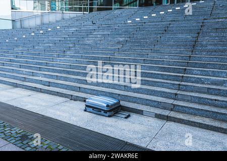 Suitcase left on a large stone staircase Stock Photo