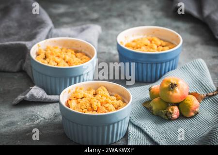 Apple crumble in small blue molds on a rustic gray table Stock Photo