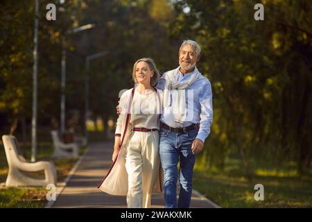 Happy senior couple walking in the park enjoying retirement and spending time together. Stock Photo