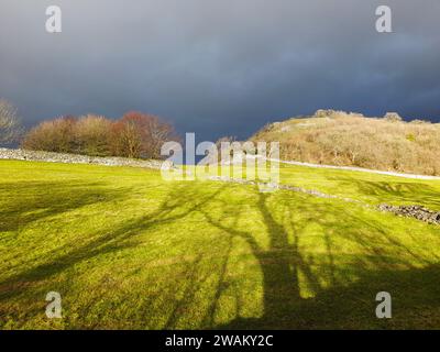 Sunlight and dark skies over Austwick, Yorkshire Dales, UK. Stock Photo