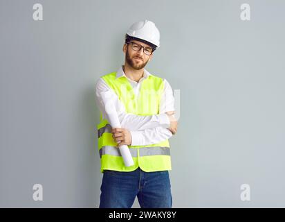 Male architect, builder or construction engineer in uniform and hard hat standing by house wall Stock Photo