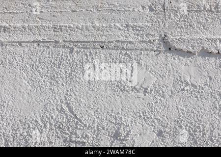 rough whitewash or white plaster wall under direct sunlight, full-frame background and texture Stock Photo