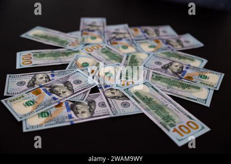 Fan of paper one hundred dollars banknotes on wooden table. Heap of money Stock Photo