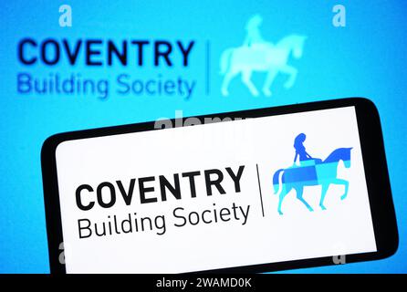 In this photo illustration, Coventry Building Society logo is seen on a smartphone and in the background. Stock Photo