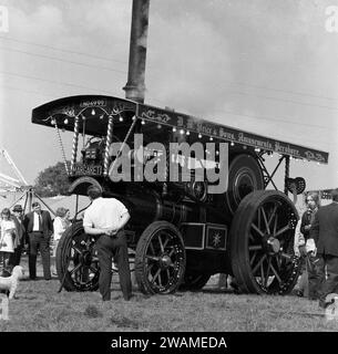 1970, historical, outside at a steam fair, visitors looking at the steam powered tractor, 'Margaret', built in 1922 and known as a Showmans Road Locomotive.  Maker's nameplate on front; C. Burrell & Sons Ltd, England. Number plate is NO 4999. Founded in 1770 and based at Thetford, Norfolk, Charles Burrell & Sons were builders of steam traction engines and related machinery and traded until the late 1920s, when the internal combustion engine became a more effective alternative to steam power. Stock Photo