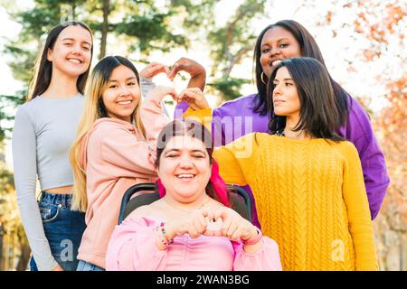 Inspire Inclusion international womens day. Diverse group do heart love with hands. Disability  Stock Photo