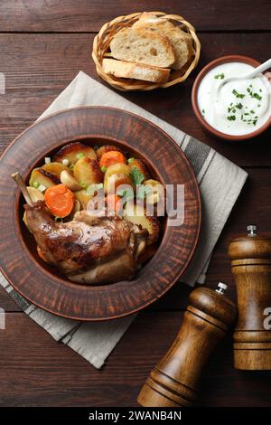 Tasty cooked rabbit meat with vegetables served on wooden table, flat lay Stock Photo